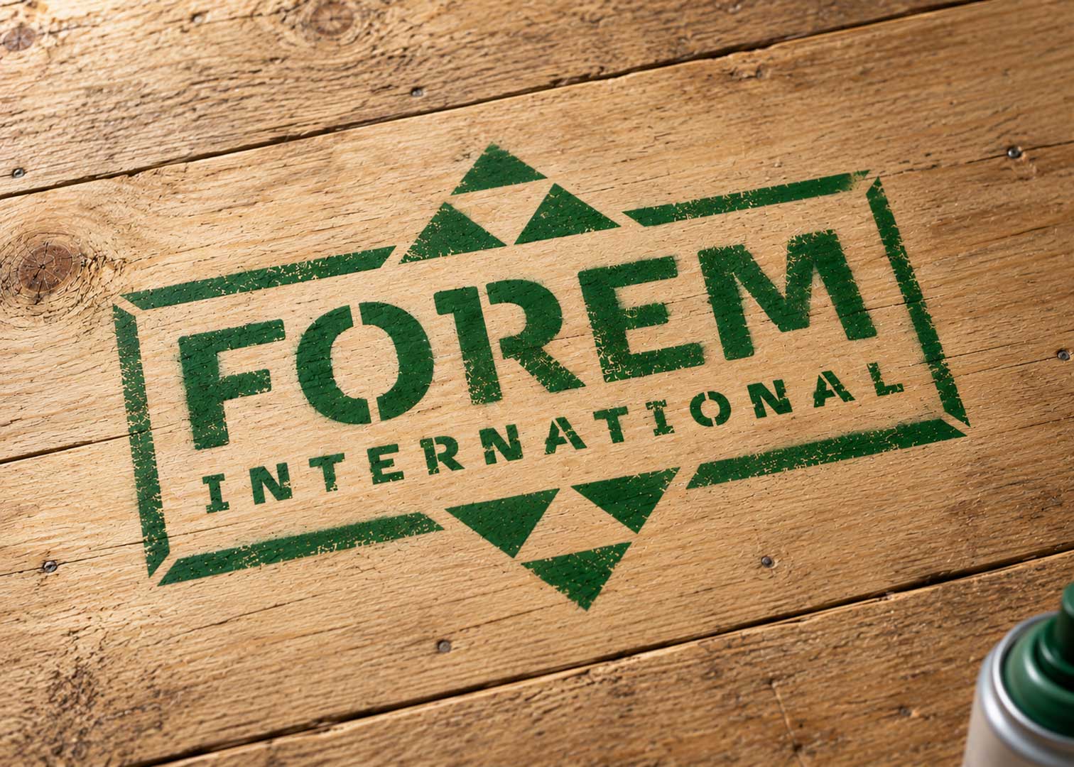 Grünes FOREM Firmenlogo mit Schablone auf eine Holzfläche gesprüht